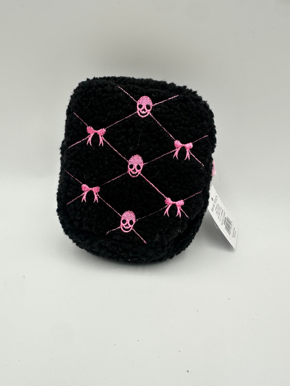 Black textured travel pouch with pink embroidered skulls and bows