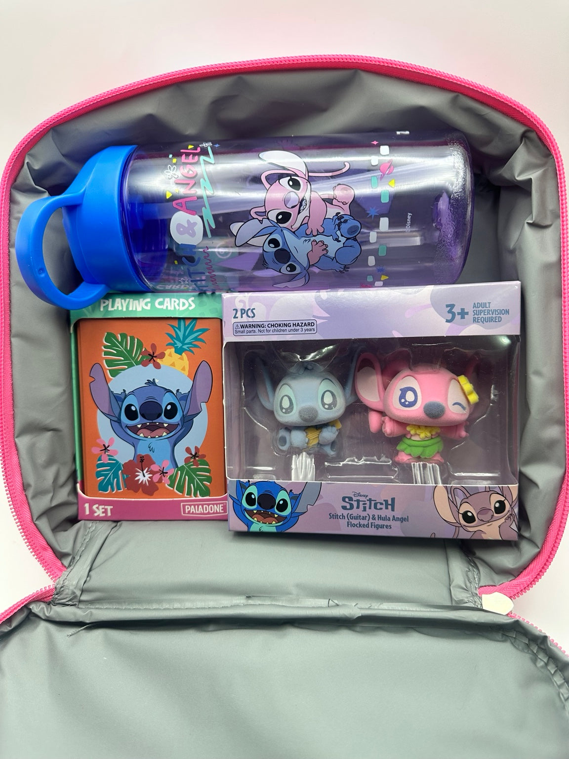 Open Stitch gift lunch bag showing the water bottle, Paladone playing cards and Stitch and Angel flocked figure pair