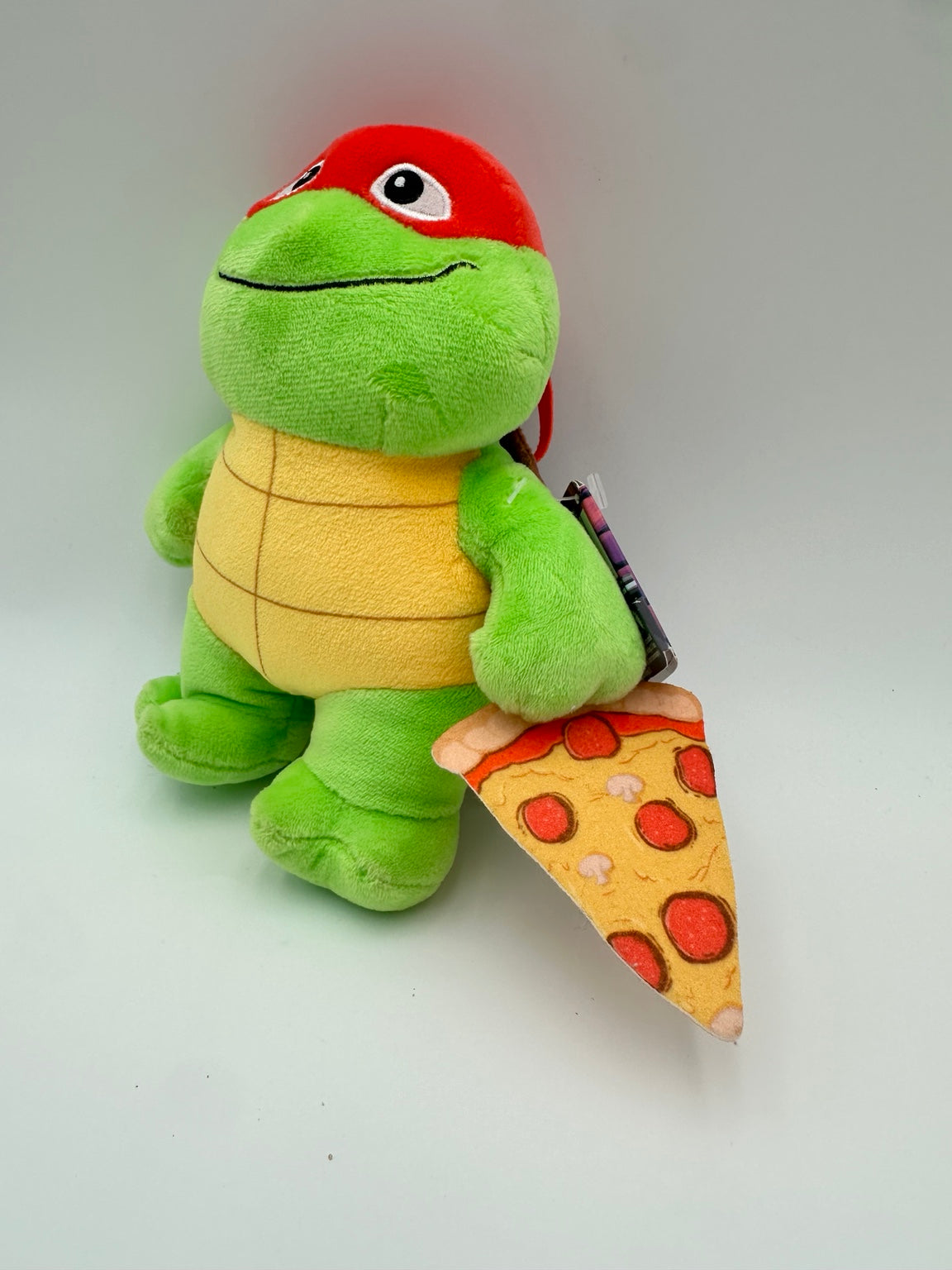 Mattel Teenage Mutant Ninja Turtles Mutant Mayhem Turtle Tot Raphael plush holding a fabric pizza slice